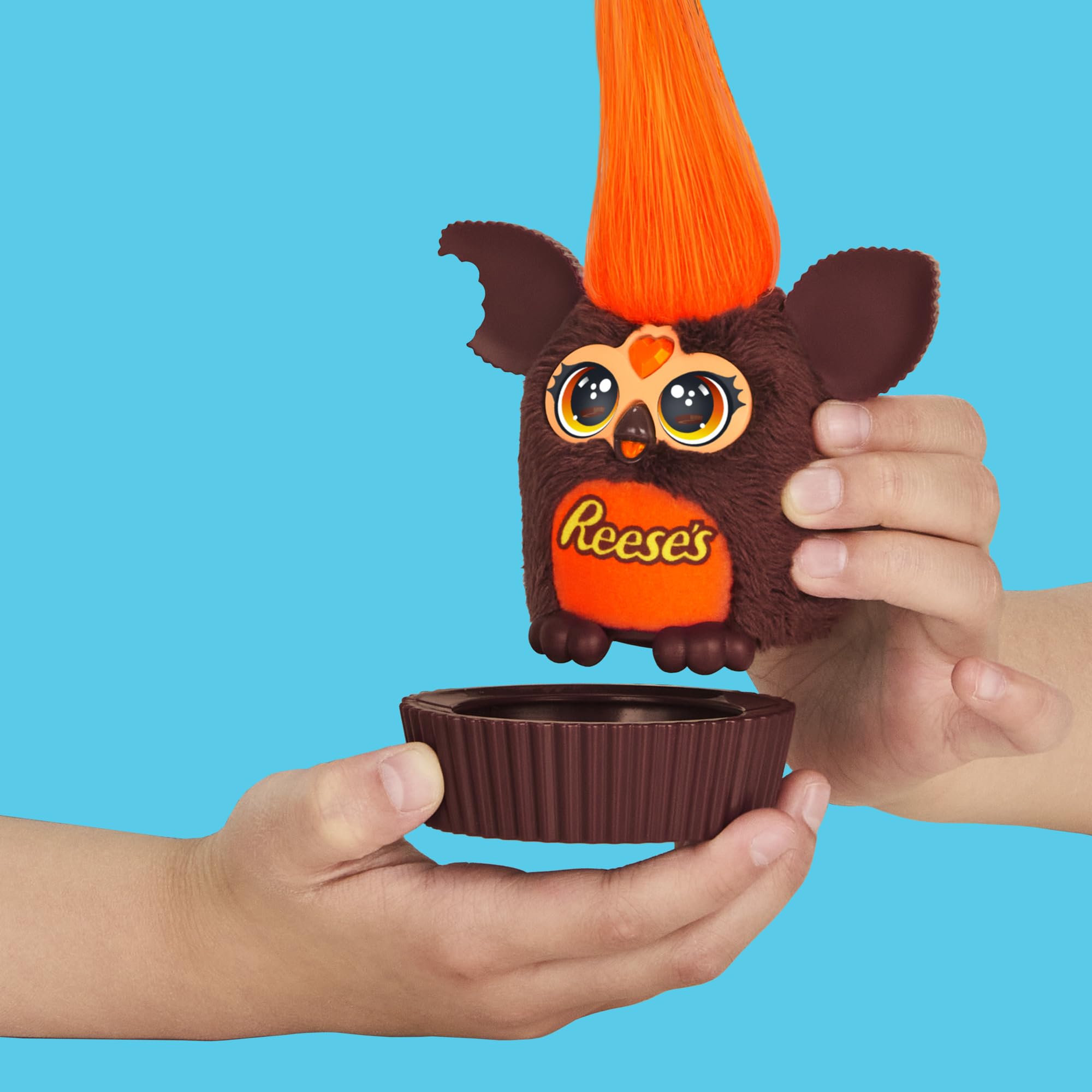 Furby Furblets mini plush sits in a pretend Reese's cup.
