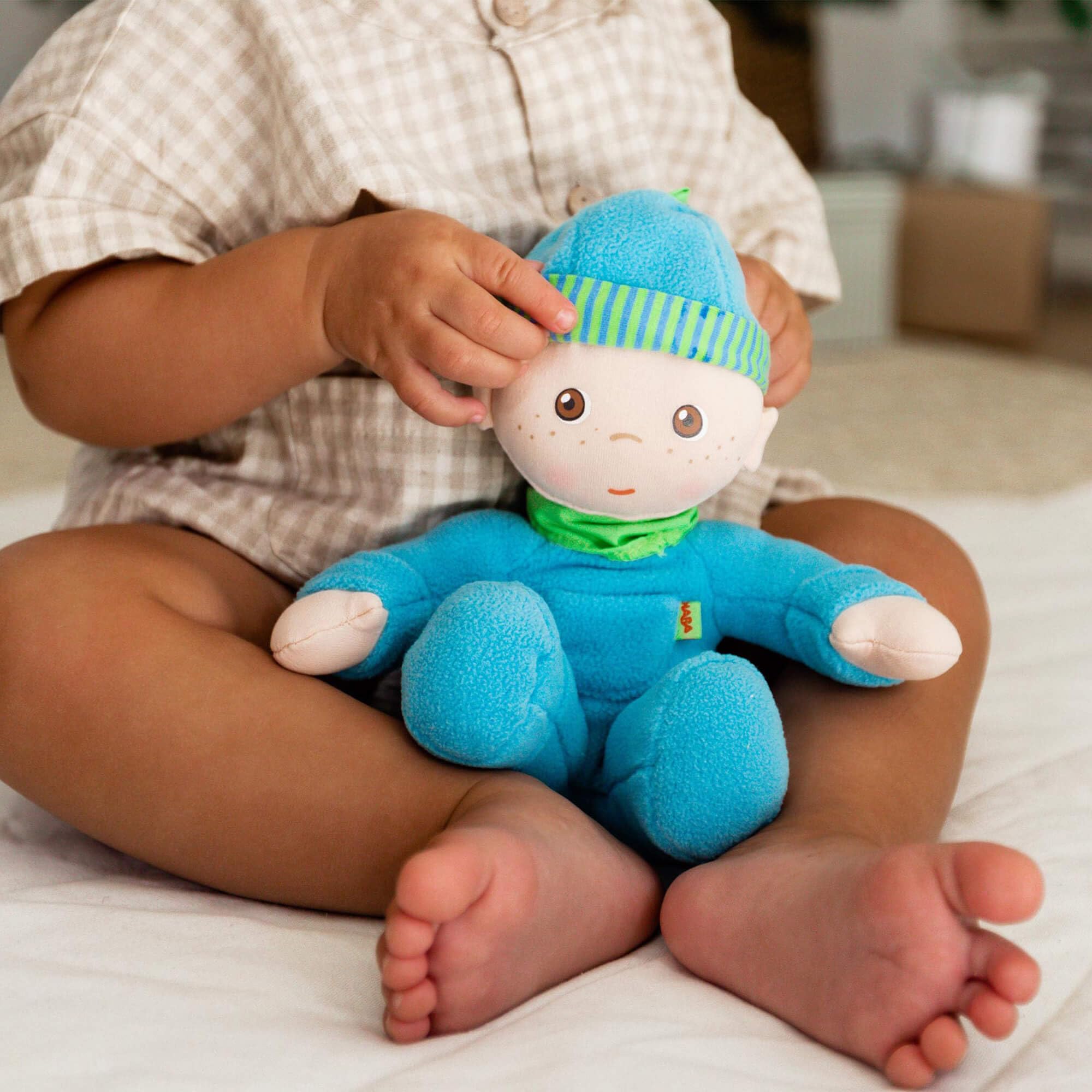 HABA Snug-Up Luis: doll in small hands sparks imaginative play.