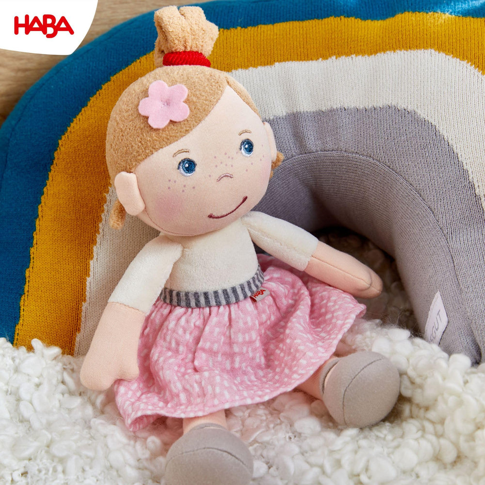 HABA Snug Up Lauren in pink skirt and white tee ready for imaginative play.