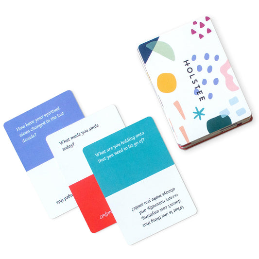 Holstee Reflection Cards in hand showing 100+ questions for meaningful conversations.