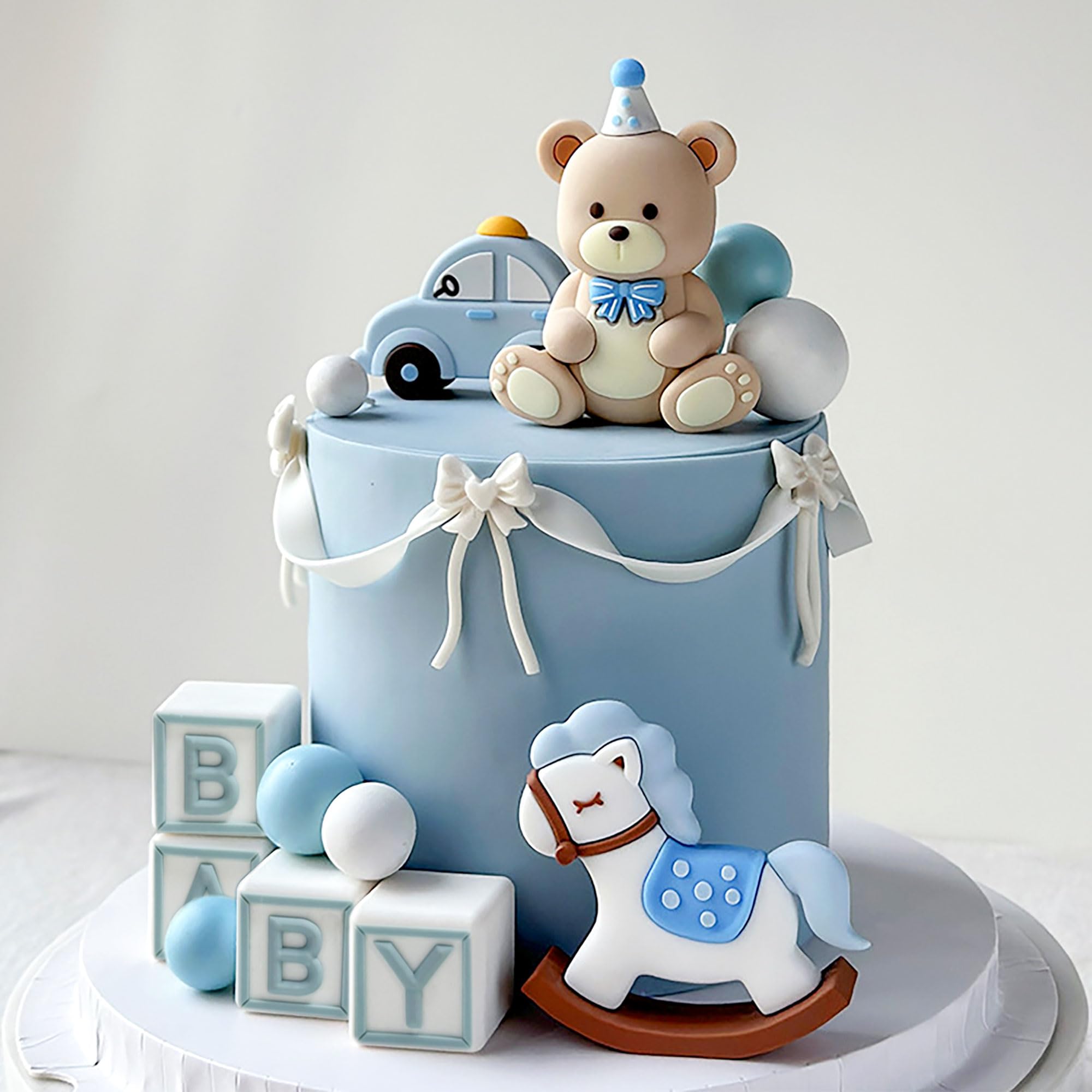 JeVenis blue bear cake topper with gold balls enhances the party centerpiece.