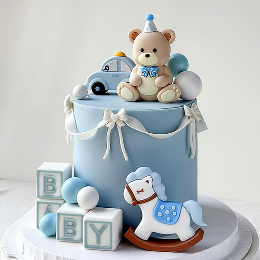 JeVenis blue bear cake topper with gold balls enhances the party centerpiece.