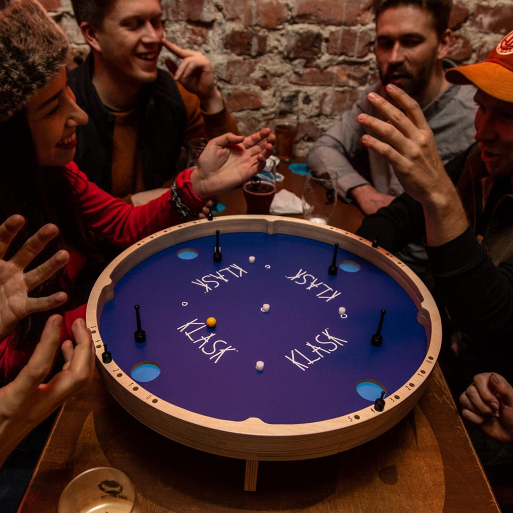 KLASK party game scene showing a lively game night setup.