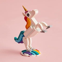 Hand holding LEGO unicorn model showing scale and portability for travel play