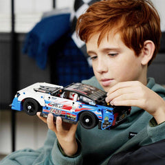 LEGO Technic NASCAR Camaro ZL1 model turned chassis shows internal mechanism in action.