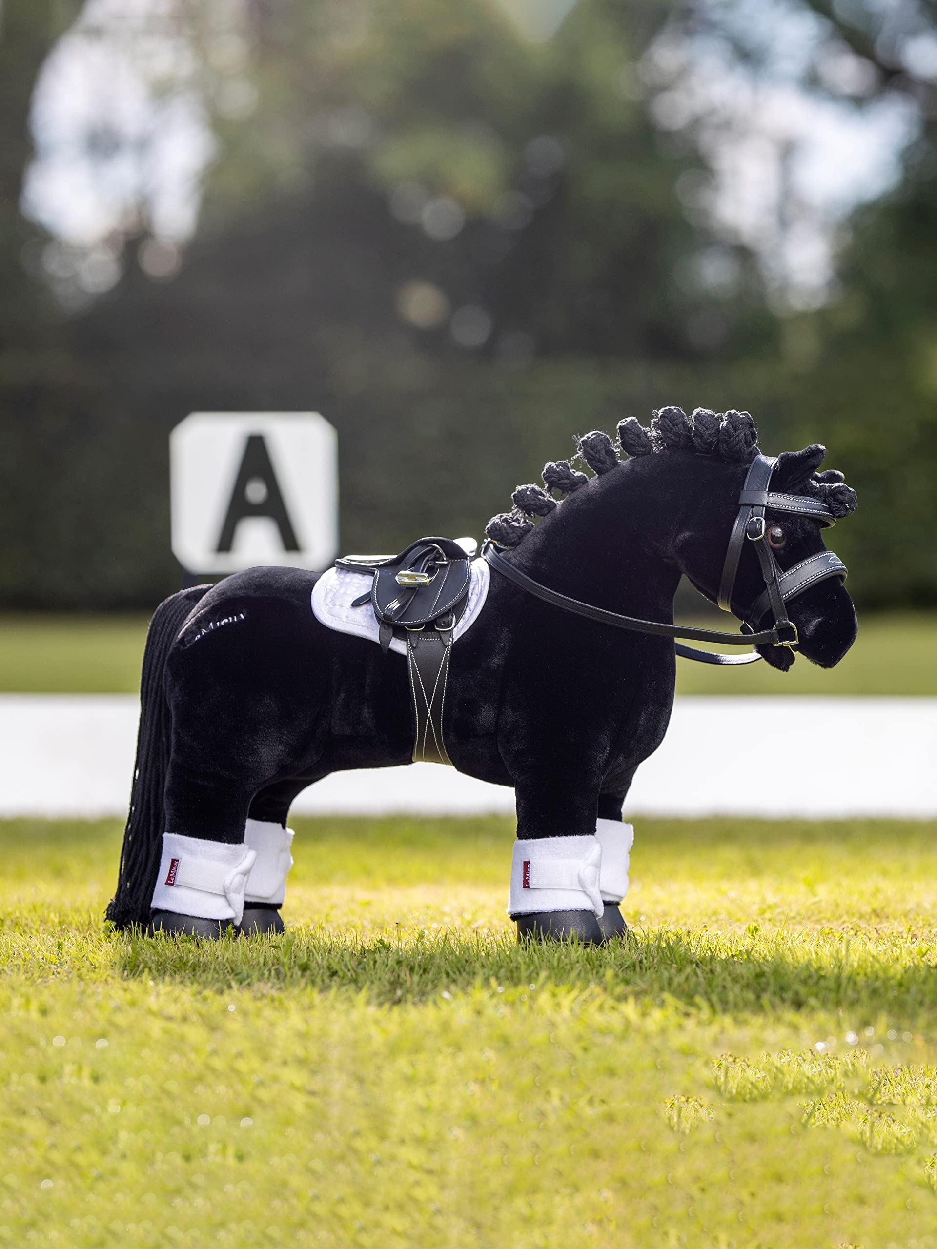LeMieux Toy Pony Saddle showing detachable girth and metal stirrups for tacking practice