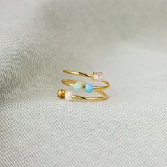 Close-up of adjustable open ring showing opal beads for calm concentration.