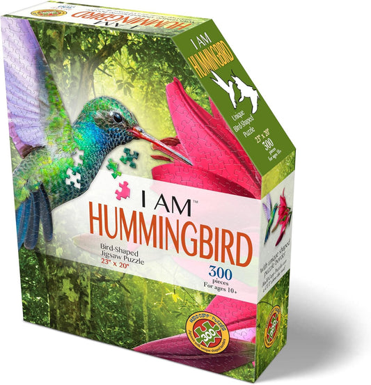 Madd Capp I Am Hummingbird puzzle cover art with pink lilies, ideal for display.