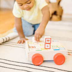 Rolling wooden cart with bright red wheels storing 30 solid blocks for stacking