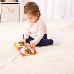 Melissa & Doug Poke-a-Dot Construction Vehicles child hands exploring tactile buttons.
