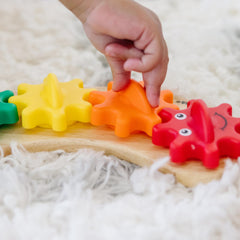 Melissa & Doug Rainbow Caterpillar Gear Toy with interchangeable gears ready to assemble on pegs.