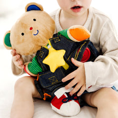 Melissa & Doug Teddy Wear bear with button closure encourages precise finger movements.