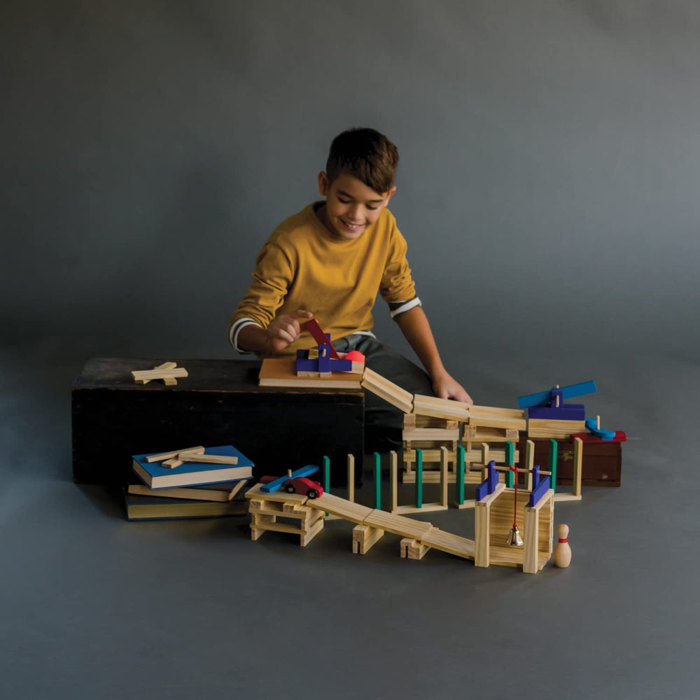 MindWare KEVA Contraptions marble maze demonstrates simple physics with ramps and tunnels.