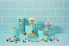 Close-up of magnets and tiny foods inside the Mini Brands fridge.