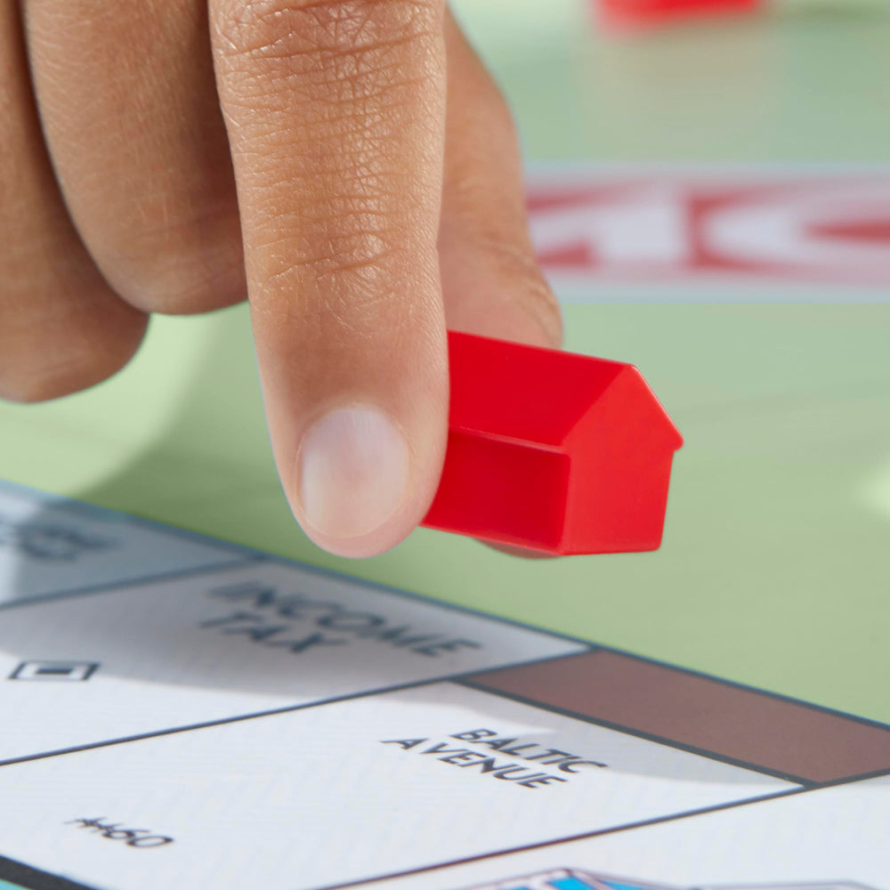All Monopoly components laid out including cards, money, and tray for easy setup