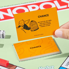 Players gathered around a table enjoying Monopoly, Monopoly brings family game nights together