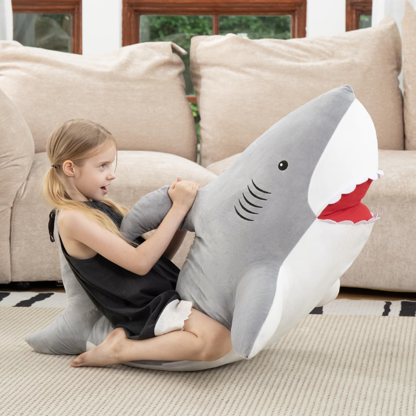 MorisMos giant shark cuddle buddy on sofa for comfy reading and relaxation.