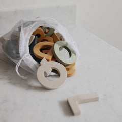 Mushie bath time foam collection on tub: soft textures invite safe, imaginative play.
