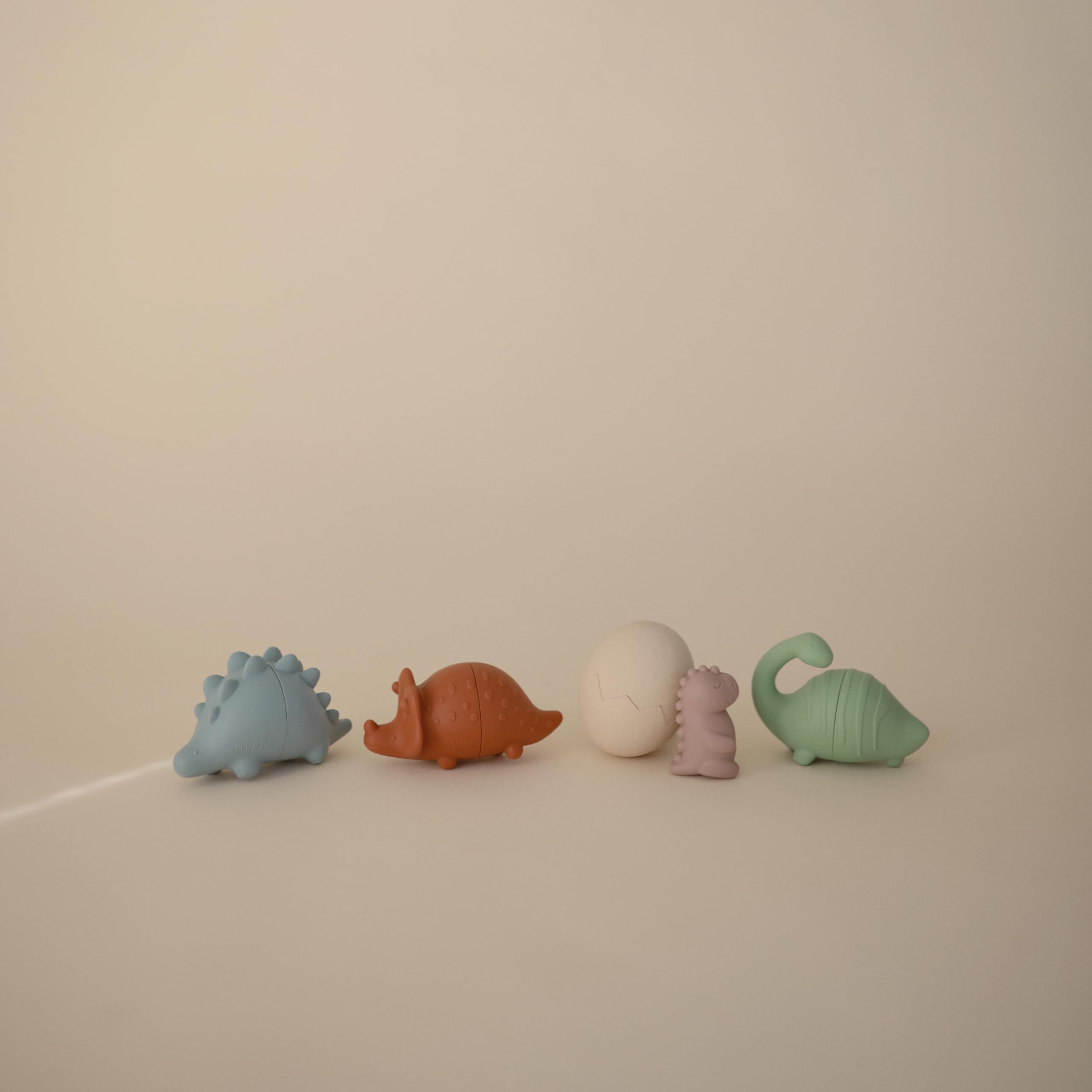 Mushie bath egg with baby dino invites gentle exploration during baths.