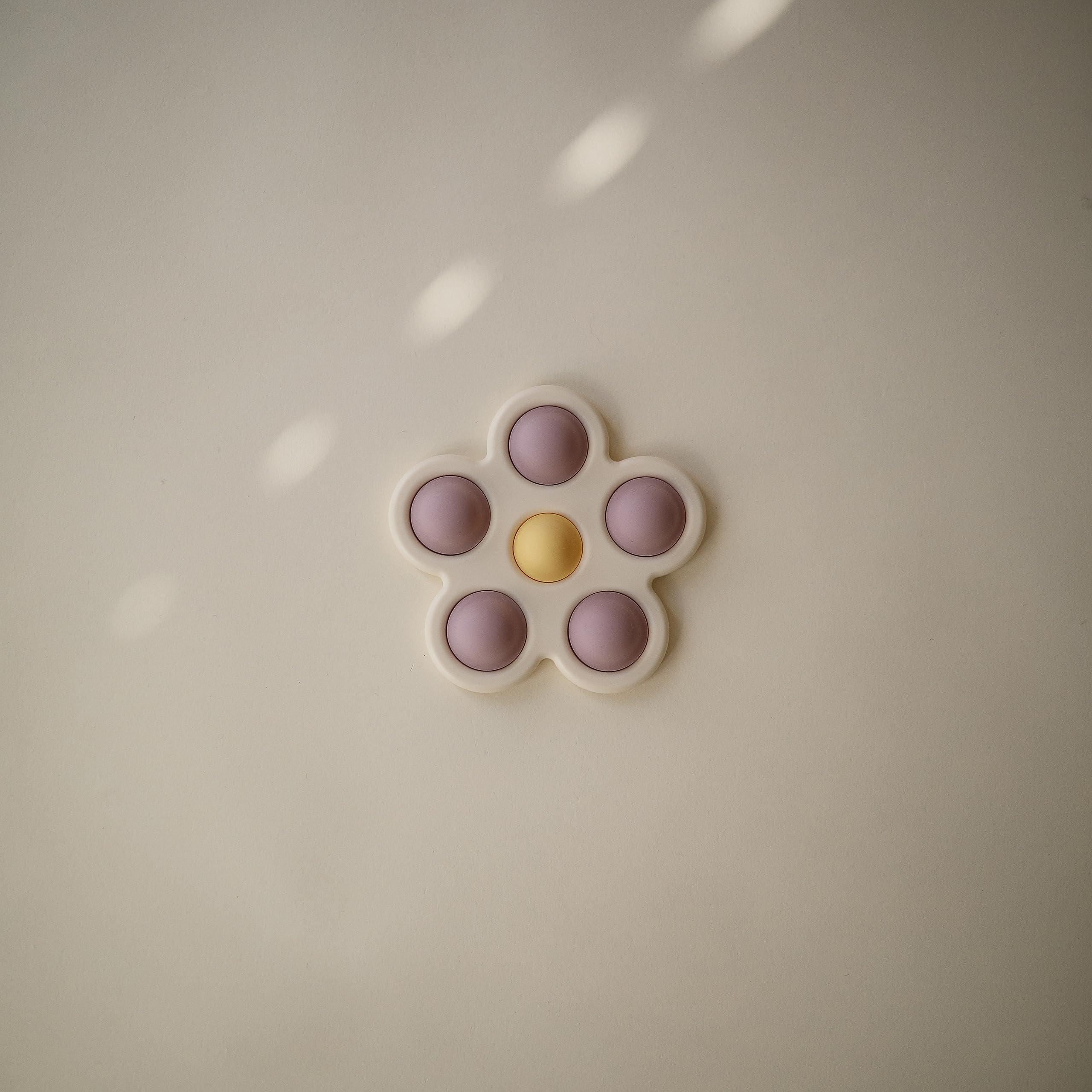 Mushie Flower Press Toy daffodil bubble closeup highlighting color play