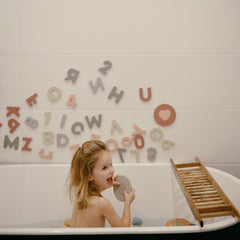 Mushie foam bath puzzle supports fine motor skills with shape fitting