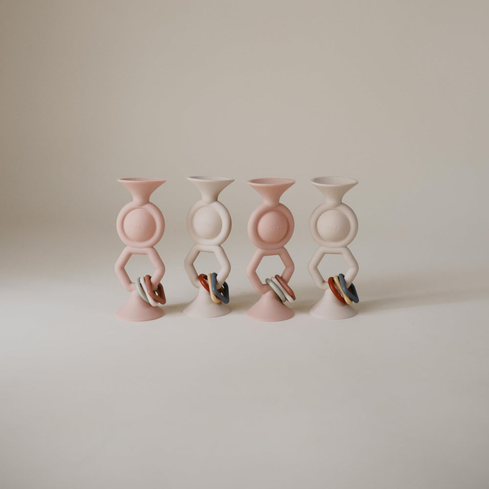 Mushie HexaPop sensory charms add tactile engagement during quiet play.
