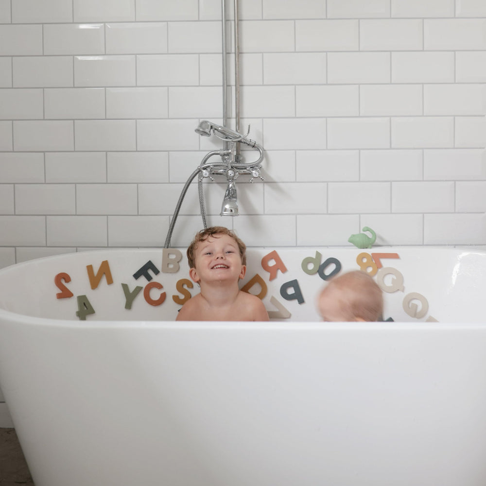 Mushie letters and numbers bath play closeup: vivid shapes spark early learning moments.