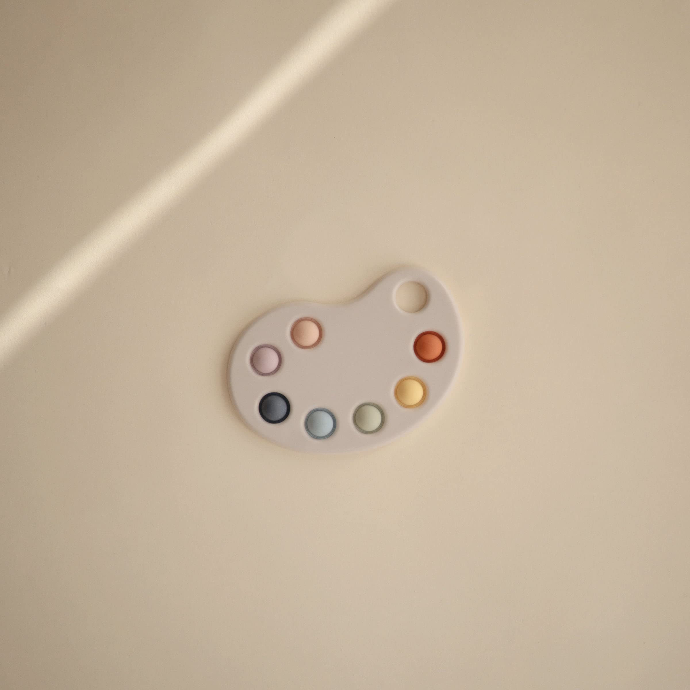 Mushie Paint Palette Press Toy children’s hands press bubbles for fine motor skills.