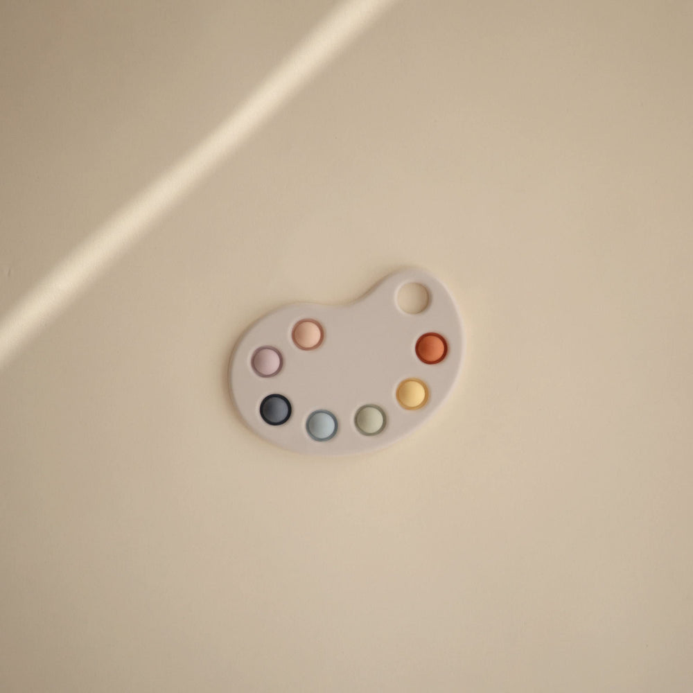 Mushie Paint Palette Press Toy children’s hands press bubbles for fine motor skills.