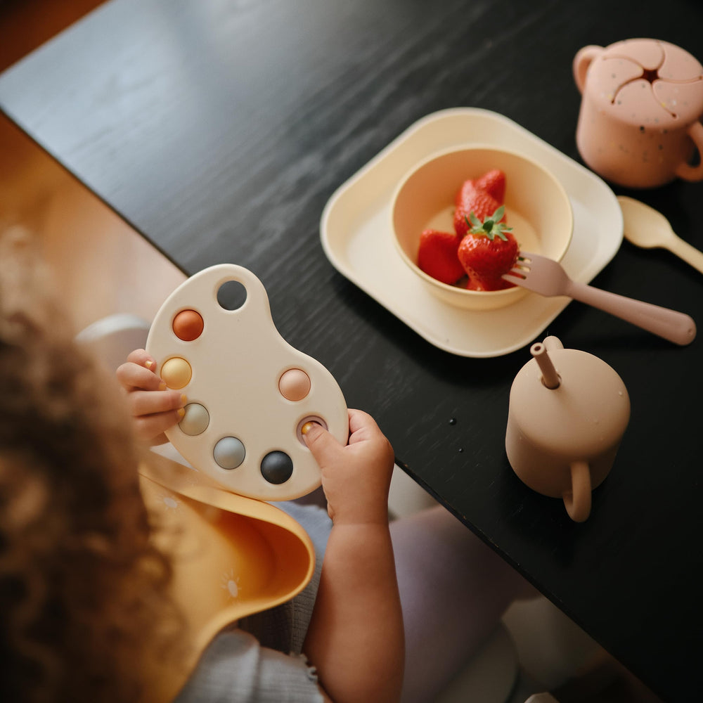 Mushie Paint Palette Press Toy in a sensory play session.