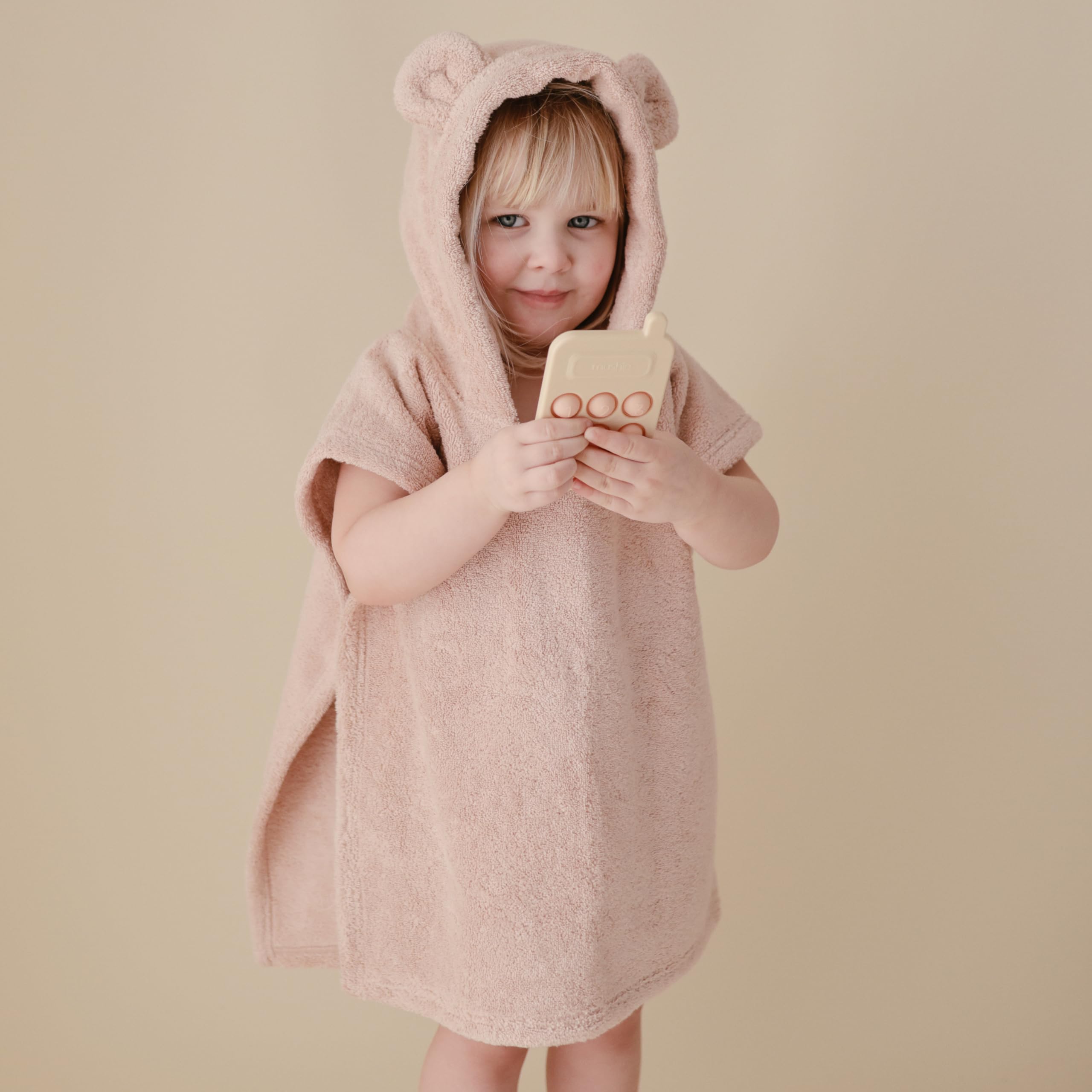 Mushie Phone Press Toy Blush resting on a playmat for tactile time