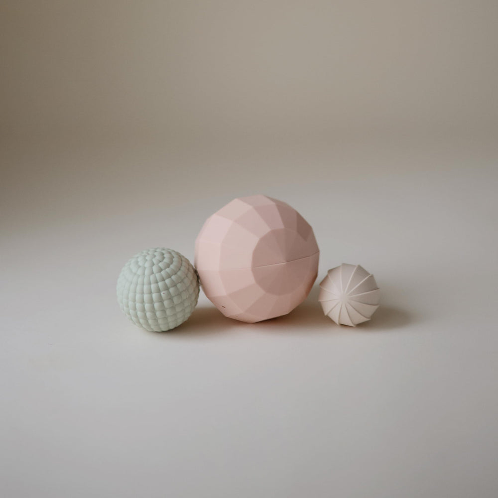 Mushie silicone nesting spheres textures promote baby sensory discovery and fine motor practice