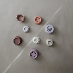 Mushie stacking cups 8pc Petal multicolor set in use.
