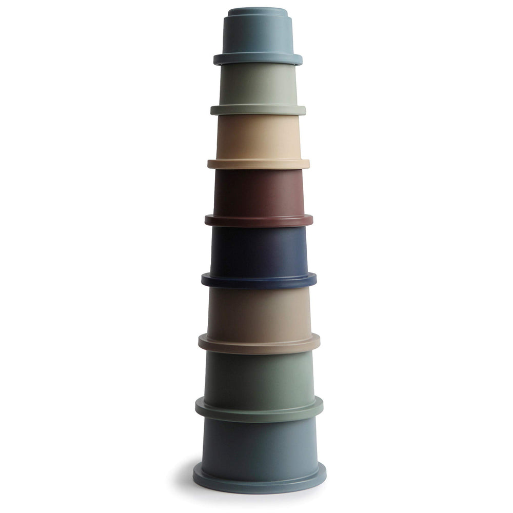Mushie stacking cups forest assembly: colorful stack aiding grasp and fine motor exploration.