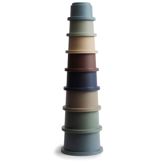 Mushie stacking cups forest assembly: colorful stack aiding grasp and fine motor exploration.