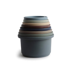 Mushie stacking cups forest colors closeup: vibrant hues spark sensory play and curiosity.