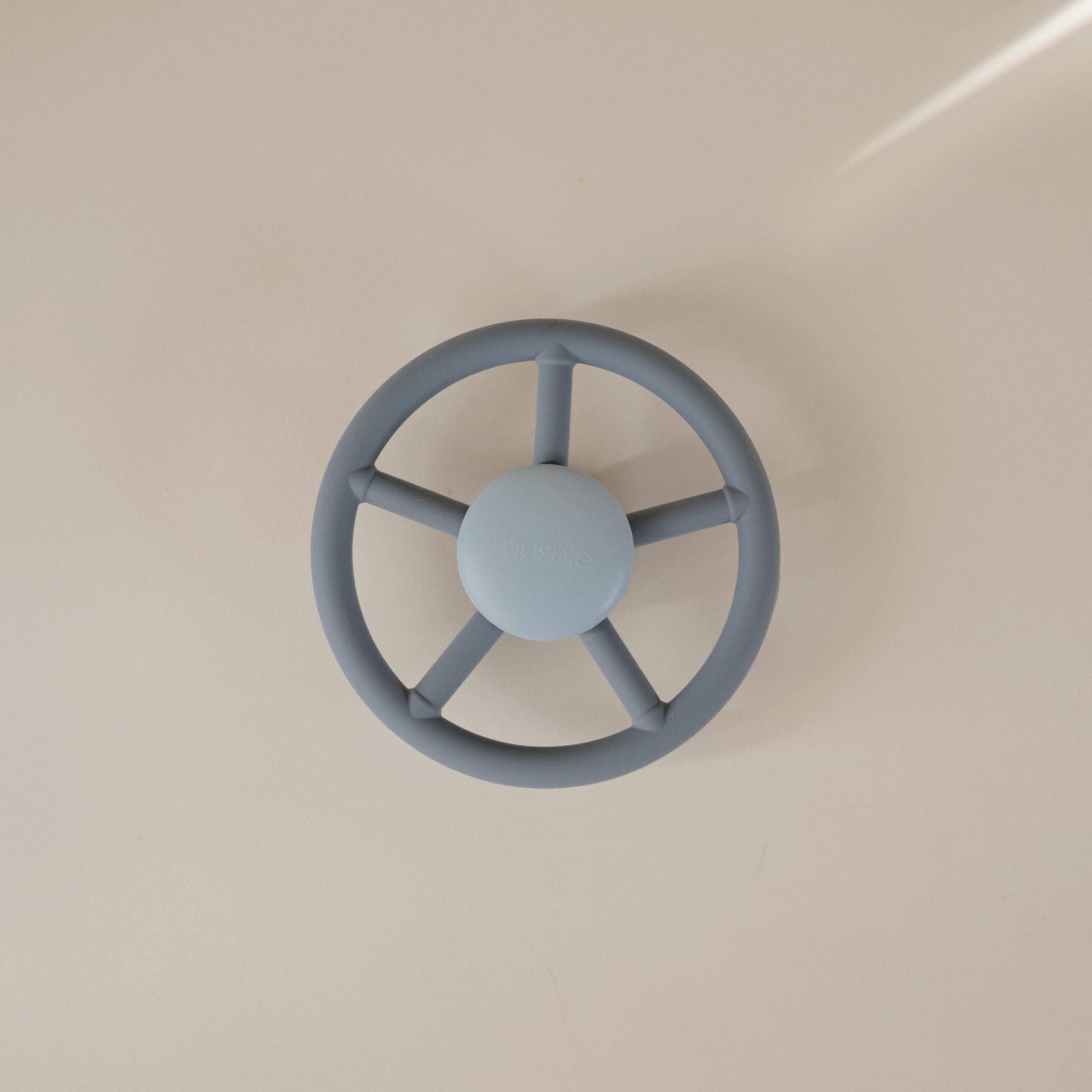 Mushie suction spinner on airplane tray for compact, engaging travel play