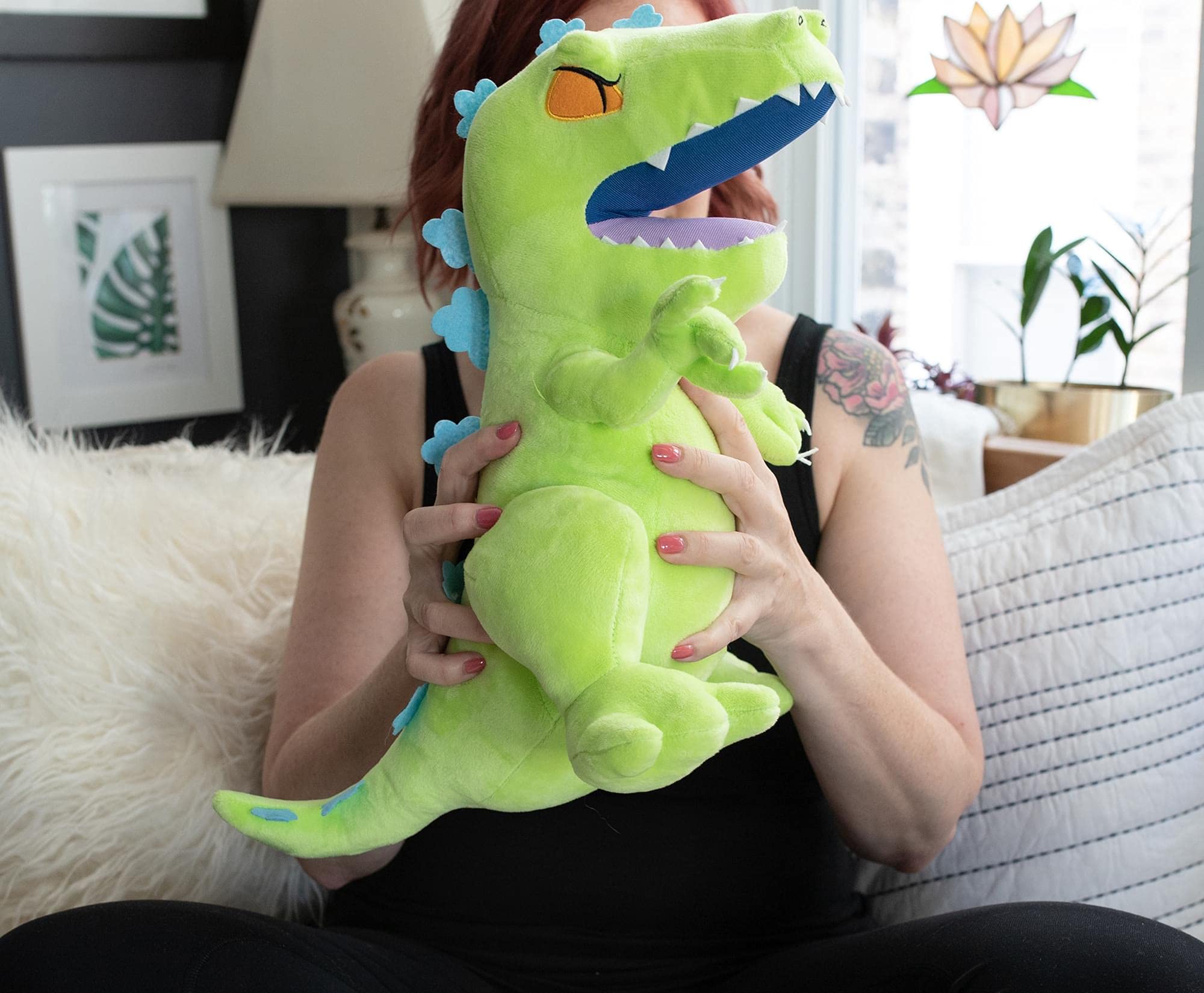 Nickelodeon Rugrats Reptar plush displayed alongside collectibles evokes nostalgia.