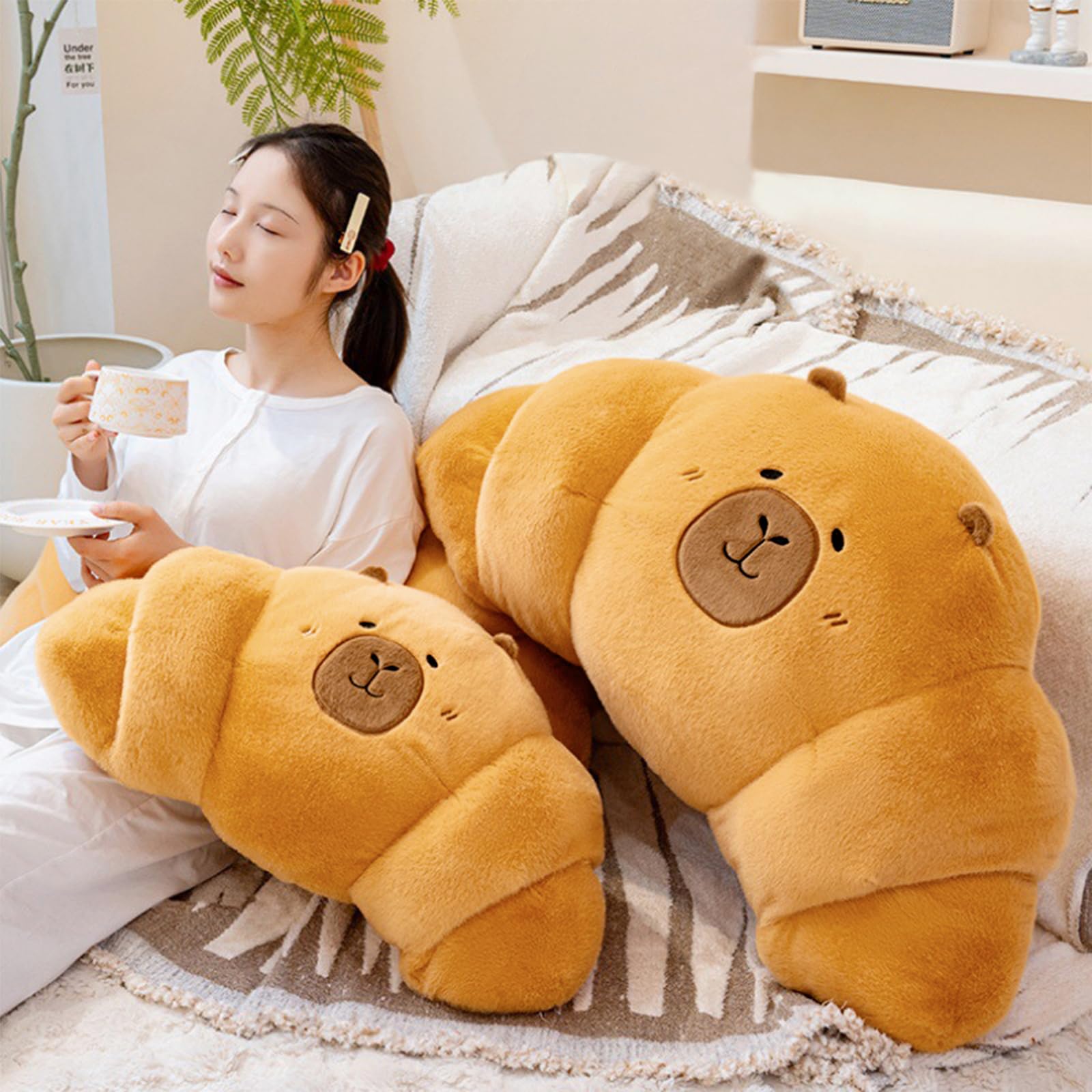 PEACH CAT croissant capybara plush, backrest on sofa, supports comfortable seating.