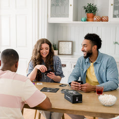 Pick Your Poison players around table enjoying a tense, humorous choice.
