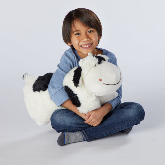 Pillow Pets Cozy Cow smiling face invites cuddles and imagination.
