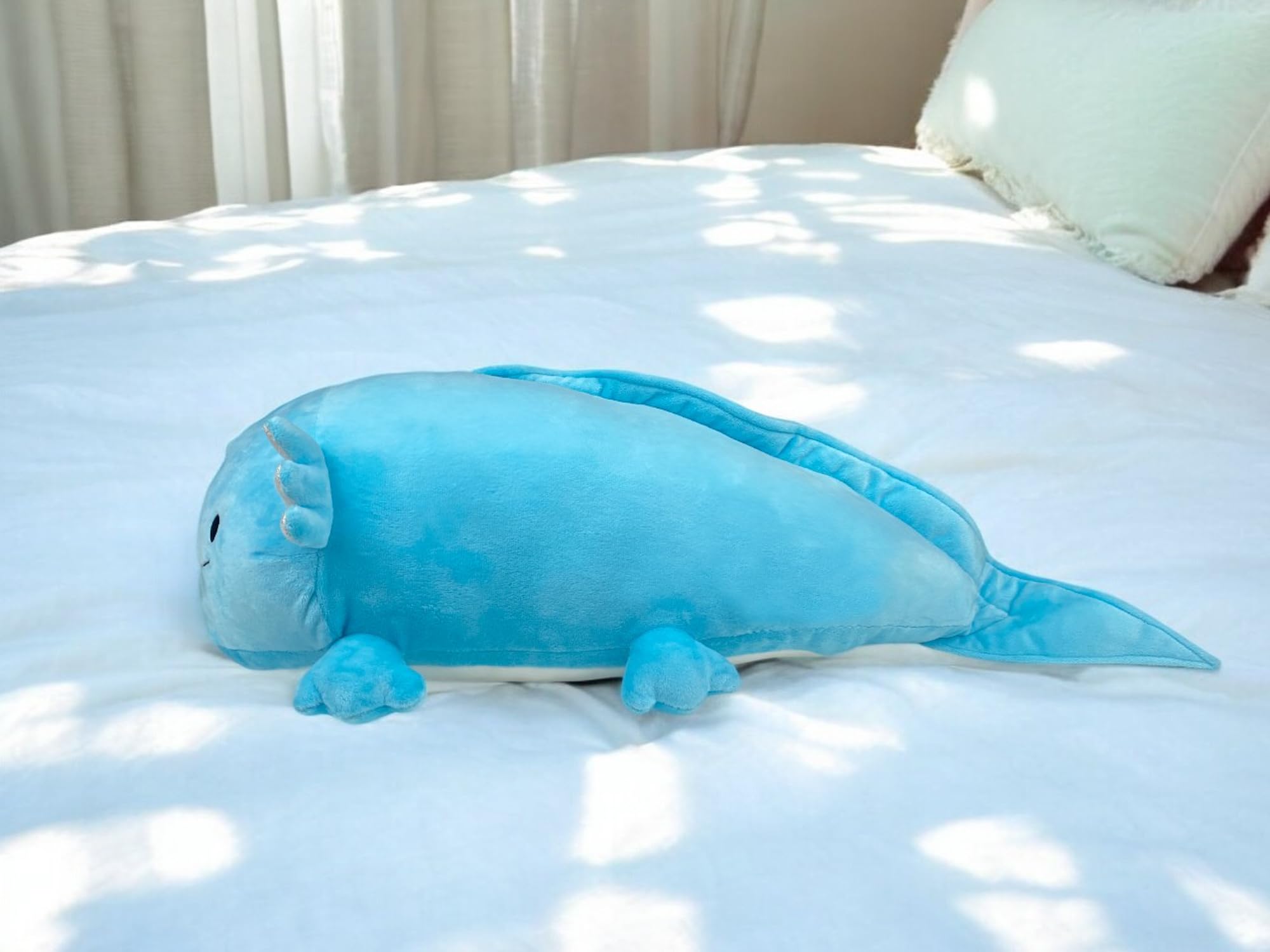 Pineapple Axolotl plush blue held by child for scale