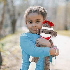 Plushland Brown Original Sock Monkey in hand, ideal gift for birthdays and special occasions.