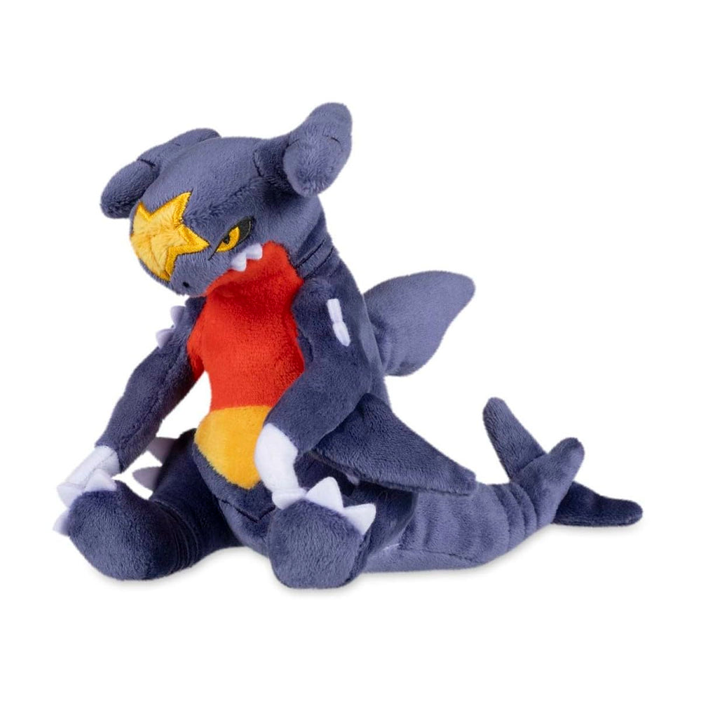 Pokémon Center Garchomp Sitting Cuties plush sits upright on a desk.