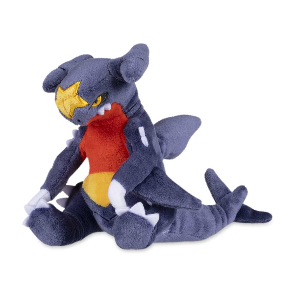 Pokémon Center Garchomp Sitting Cuties plush sits upright on a desk.