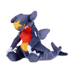 Pokémon Center Garchomp Sitting Cuties plush sits upright on a desk.
