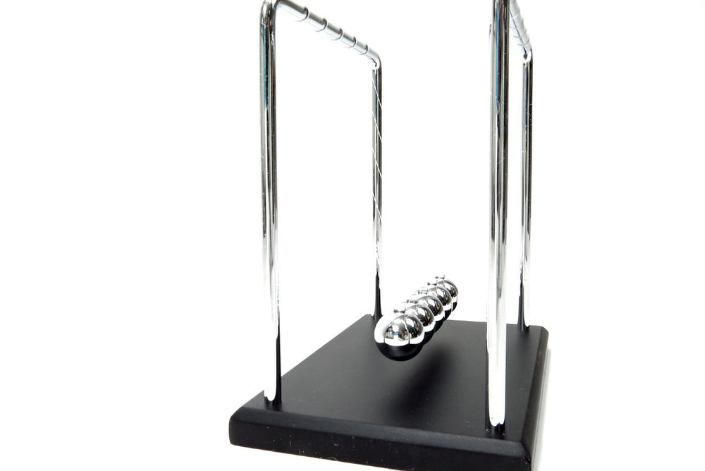 PowerTRC Newtons Cradle on an office shelf as stylish science-inspired decor and gift option