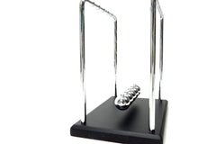 PowerTRC Newtons Cradle on an office shelf as stylish science-inspired decor and gift option