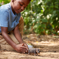 Schleich hippo in Wild Life setting, realistic details for educational storytelling.