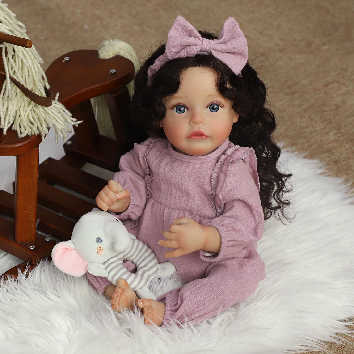 SCOM lifelike reborn doll posed in a nursery setup for storytelling play.